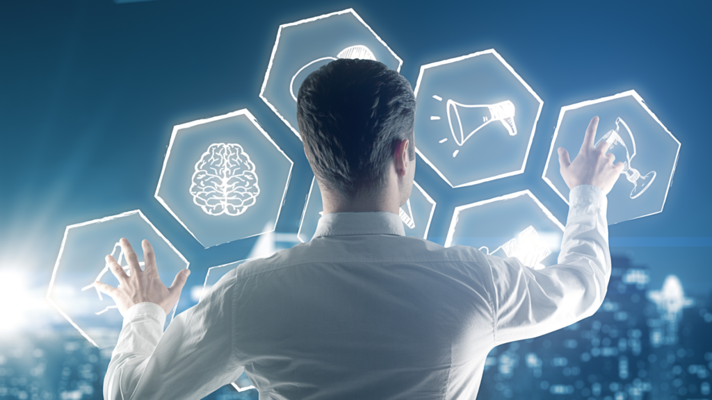 Persona de espaldas, de pie frente a una pantalla virtual, interactuando con íconos tecnológicos como un cerebro, un megáfono y una copa, sobre un fondo urbano moderno y nocturno